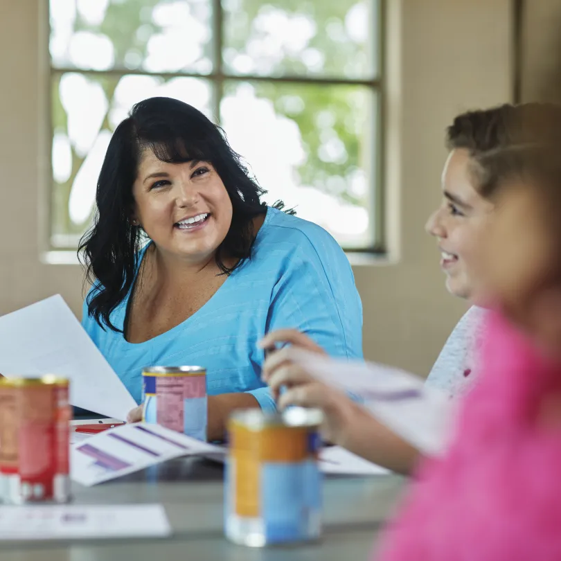A woman smiles as she reads a worksheet in a health and nutrition diabetes prevention class.