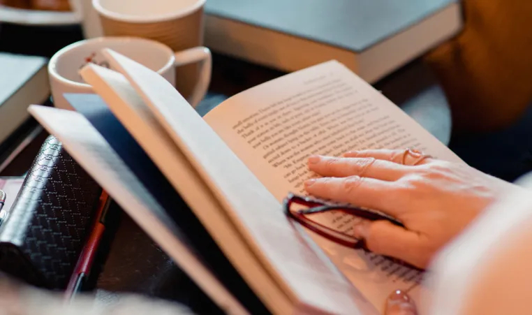 A closeup of someone holding a book during a book club meeting.